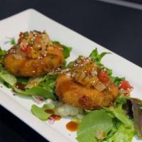 Crab Cakes · Two crab cakes served over a bed of greens tossed in oriental sesame dressing with a teriyak...