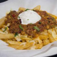 Chili Fries · Homemade chili con carne with cheddar cheese and topped with sour cream over a bed of fries.