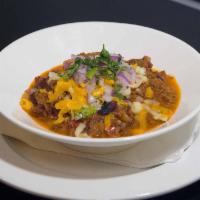 Chili Con Carne · Homemade Chili with chunks of beef topped with cheese, onions and sour cream.