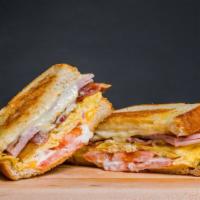 Breakfast Club Melt · Thick grilled sourdough bread with scrambled eggs, ham, bacon, american and swiss cheese, to...