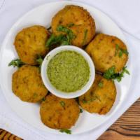 Alu Tikki · Seasoned potatoes and peas fried in our chickpea batter.