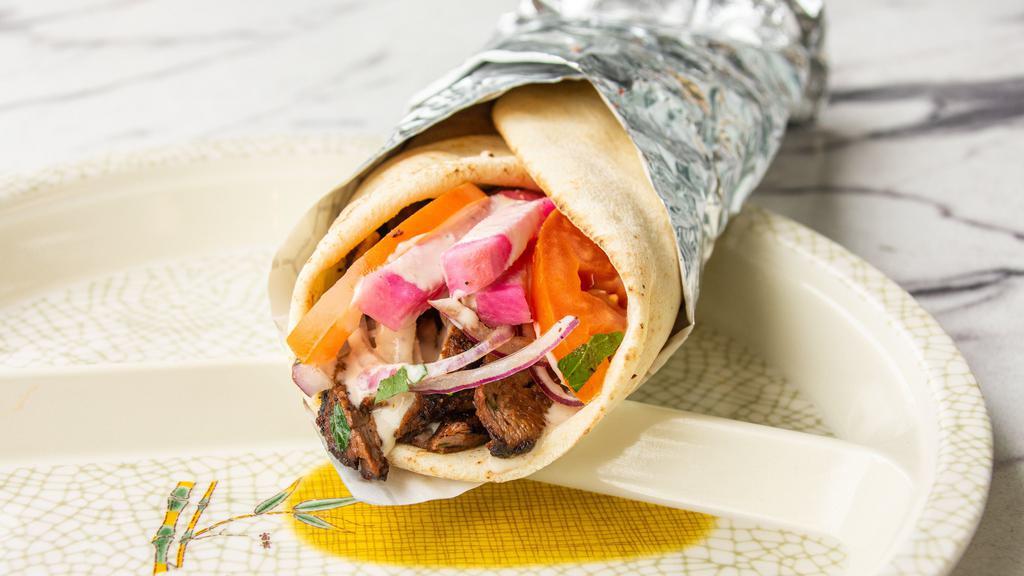 Beef Shawarma Wrap · Served with marinated beef shawarma strips wrapped in pita bread with tomatoes, lettuce, onion, and tahini sauce.