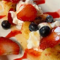 Cowboy Cake · Buttery cornbread toasted on the griddle and layered with whipped cream and fresh berries.