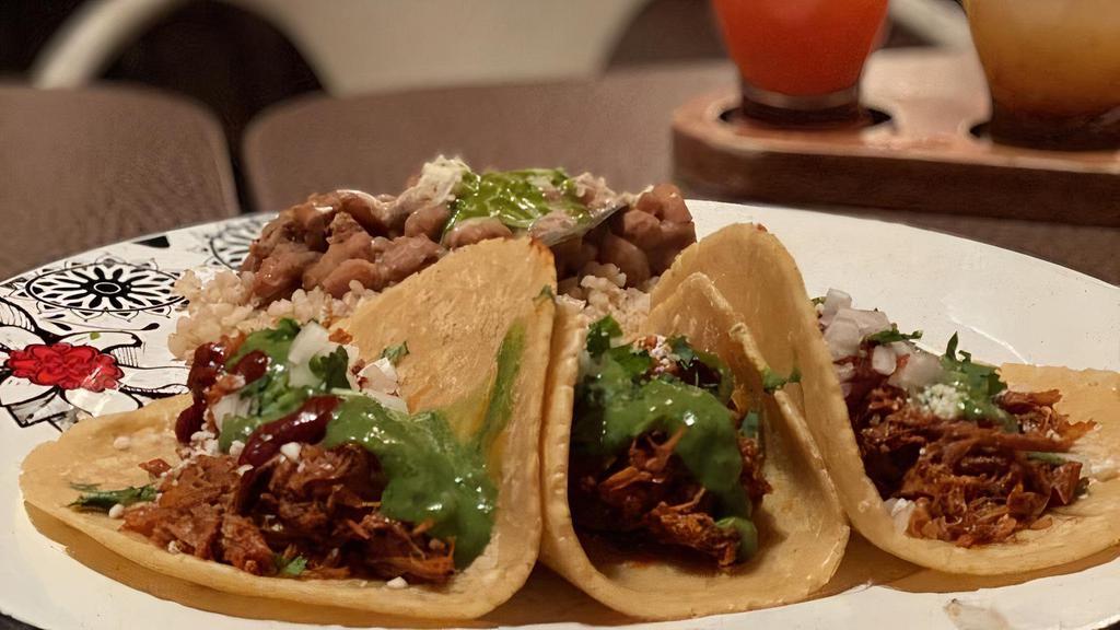 Carnitas Tacos · Gluten free. Oven-baked carnitas, cotija Cheese, avocado sauce, chile guajillo, onion, cilantro.