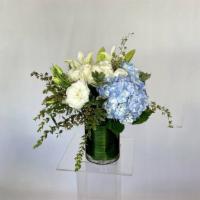 Sea  Breeze · White Roses, Blue Hydrangea, Asiatic Lilies, Assorted Greens  Arranged in a clear glass vase.