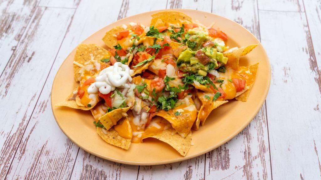 Nachos · Corn chips, beans, nacho cheese, sour cream, guacamole and choice of meat. Make them Super Nachos with shredded cheese and pico de gallo for a cost.