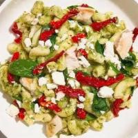 Pesto Menace Mac · Tender chicken, creamy pesto, sun-dried tomatoes, and spinach cooked in a blend of creamy ma...
