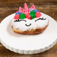 Unicorn Donut · Large yeast ring dipped in cake batter glaze and topped with fun butter cream colors, chocol...