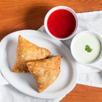 Veggie Samosas · Two pastry shells stuffed with potatoes, roasted cumin, peas, and onions