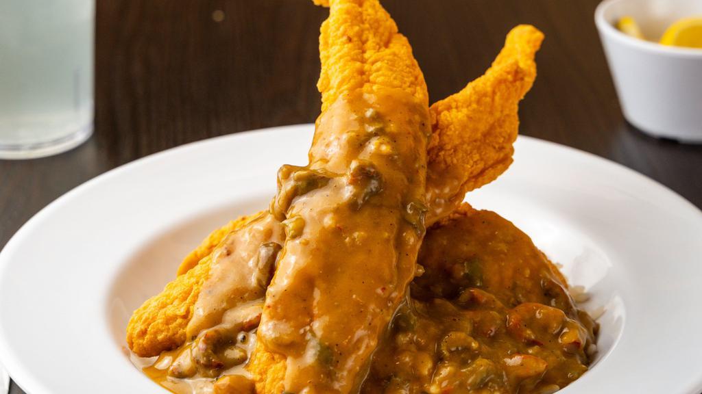 Cat-Touffeé · 3 strips of Southern fried catfish glazed with crawfish etouffee over a bed of rice. Served with garlic French bread.