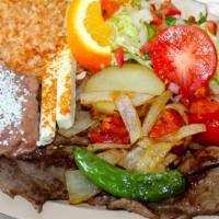 Carne Asada Plate · Plato con un biste de asada servido con arroz y frijoles, acompanado por tortillas hechas a ...