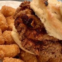 Fried Chicken Biscuit And Crunchy Tater Tots · Tender fried chicken breast in between house made butter biscuits and topped with scratch ma...