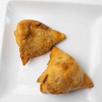 Vegetable Samosa · Two crisp patties stuffed with potatoes, green peas, and spices.