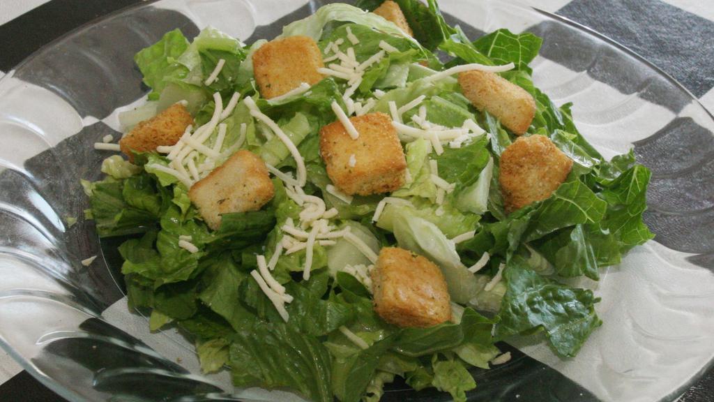 Caesar Salad · Romaine lettuce and croutons tossed in our homemade caesar dressing. Topped with grated Parmesan.