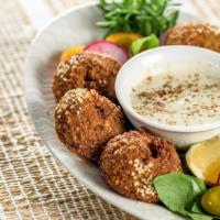 Falafel Plate · Crispy fried chickpeas on bed of fresh rice, salad, chef's sauce and side of bread.