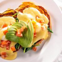 Veggie Eggs Benedict · Two poached eggs on an English muffin, topped with tomato, spinach, and avocado, covered wit...