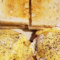 Eggs Benedict · Slices of ham and poached eggs on an English muffin topped with Hollandaise sauce. Home frie...
