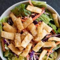 Asian Crispy Wonton Salad · Romaine lettuce, shredded purple cabbage, carrots, and crispy wontons, topped with house-mad...