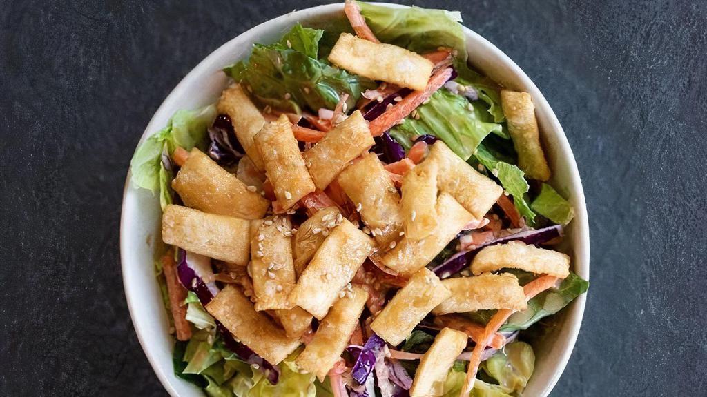 Asian Crispy Wonton Salad · Romaine lettuce, shredded purple cabbage, carrots, and crispy wontons, topped with house-made creamy sesame dressing.