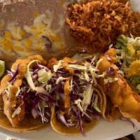 Shrimp Or Fish Tacos · Three soft corn tortilla tacos layered
with marinated cabbage, guajillo aioli, choice of bee...