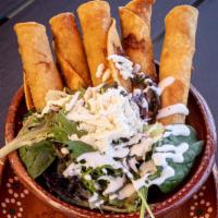 Mexicali Taquitos · 6 crispy taquitos (3 Chicken - 3 Beef) served with a tangy tomatillo chicken broth, greens, ...