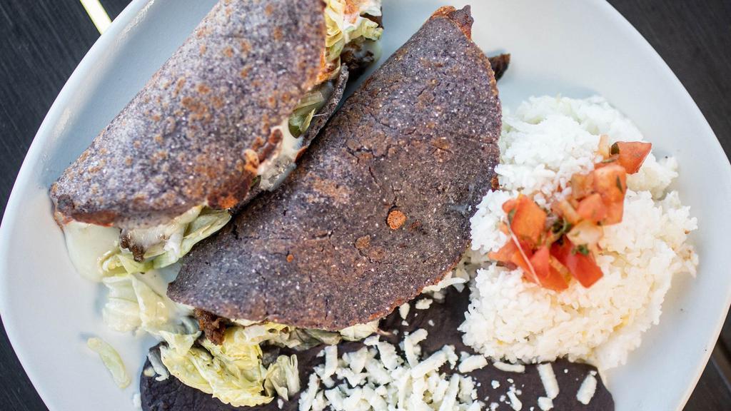 Quesadilla Chilangas · A variation of a taco, made from a grilled crisp handmade corn tortilla with a mix of Mexican cheeses, your choice of Chando's Signature Meats (2 Selections), lettuce, salsa, crema and queso cotija. Two per order, comes with rice and beans.
