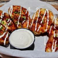 Potato Skins · Six potato skins topped with garlic aioli, cheddar jack cheese, applewood smoked bacon, chiv...