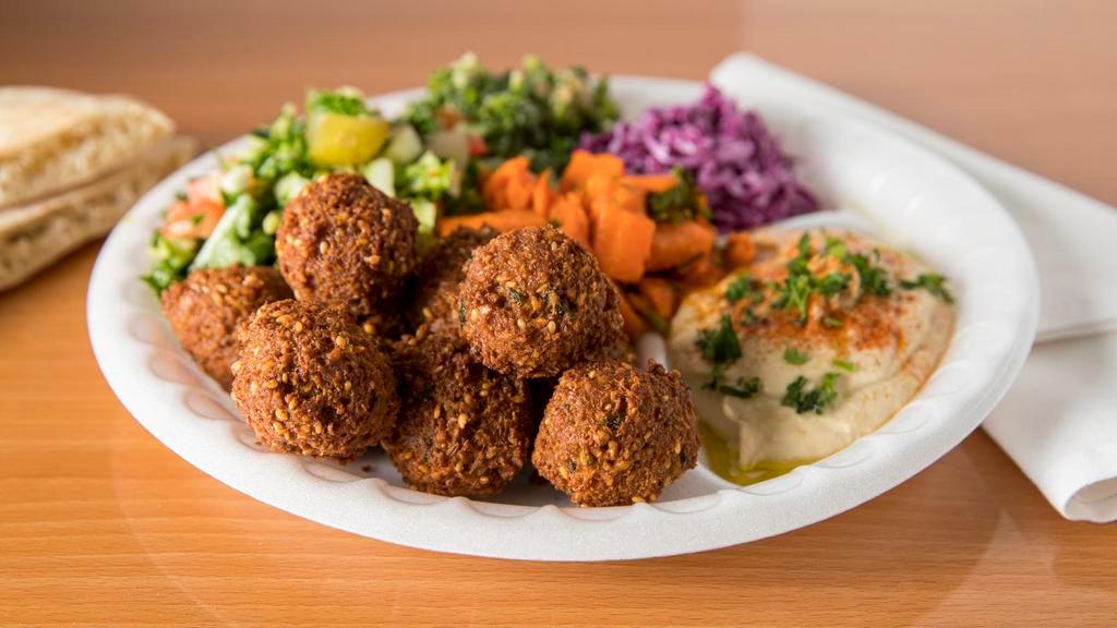 Falafel Plate · Served with crispy falafel balls (10), mediterranean sides (5), a freshly-baked pita bread, and your choice of sauces.