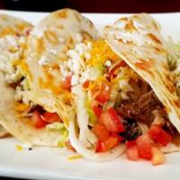 Judos' Tacos · An original creation crafted by the owner's son. Camitas, cheese, black beans, lettuce, toma...