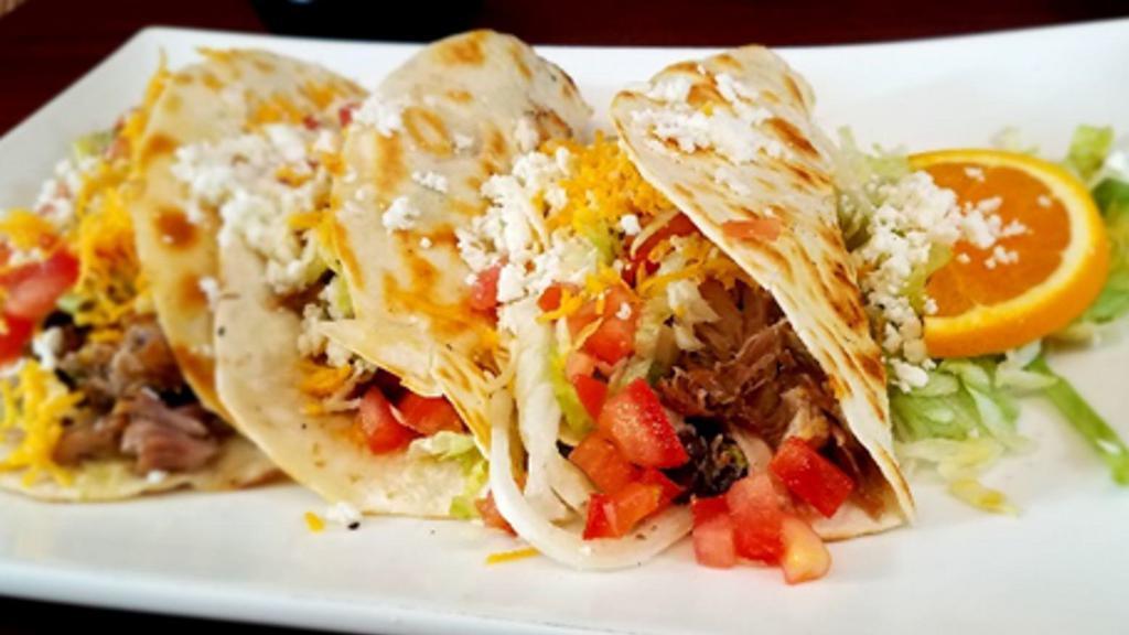 Judos' Tacos · An original creation crafted by the owner's son. Camitas, cheese, black beans, lettuce, tomatoes, and 