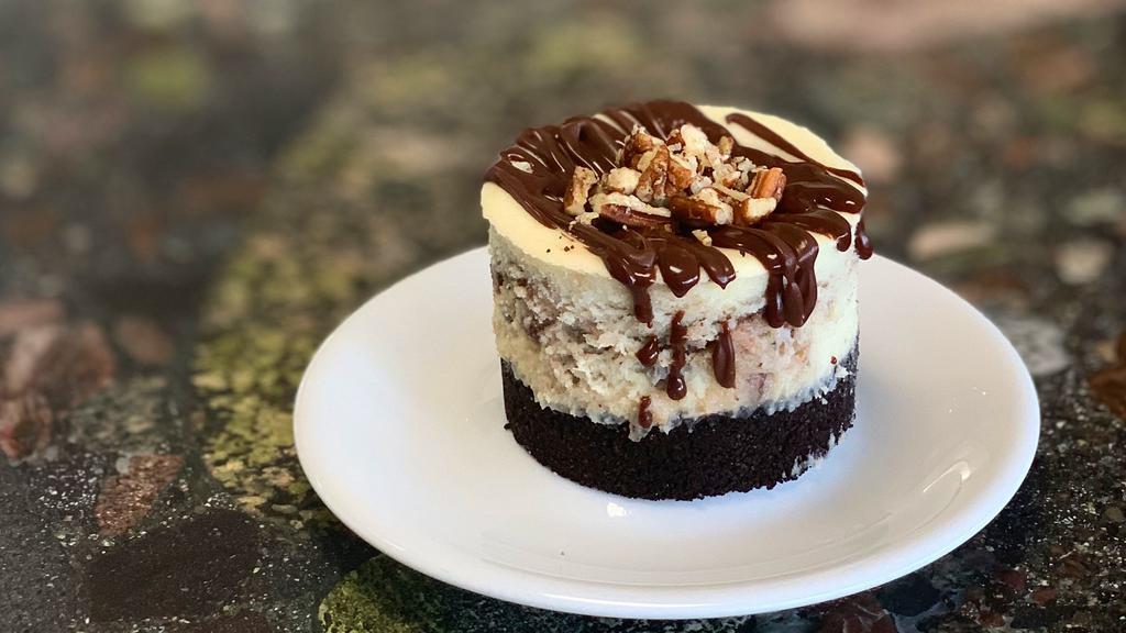 German Chocolate Cheesecake · Our traditional cheesecake swirled with coconut pecan filling and chocolate ganache, on an oreo crust