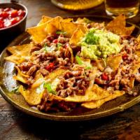 Og Shredded Beef Nachos · Nachos loaded with shredded beef, black beans, cheese, tomatoes, cilantro, and onions.