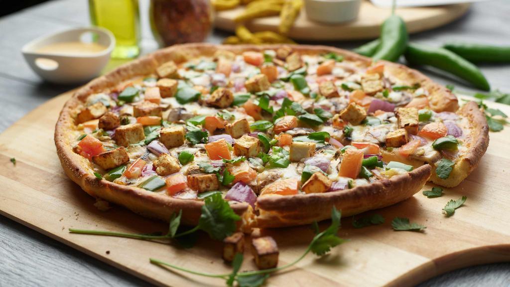 Paneer Tikka Masala Pizza Twist · This pizza has our signature tikka sauce, masala paneer, fresh diced mozzarella cheese, fresh  mushrooms, crisp red onions, juicy tomatoes, fresh bell peppers, fresh cut; garlic, ginger, and green chilies,  garnished with fresh cilantro