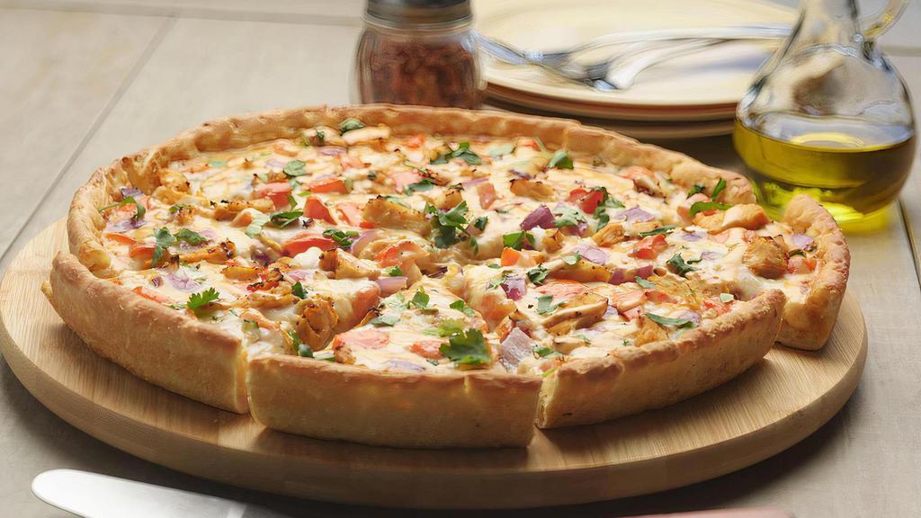 Vegan Butter Chicken Pizza Twist · This pizza has our signature vegan butter sauce, signature vegan cheese, vegan chicken, fresh crisp red  onions, juicy tomatoes, fresh cut; garlic, ginger, and green chilies, garnished with fresh cilantro