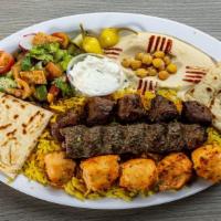 Ali Baba Combo Plate · One skewer chicken tawouk, one skewer beef kabob and one skew kofta sitting on a bed of rice...