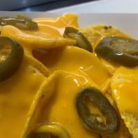 Nachos · Tortilla chips covered in nacho cheese and topped with jalapenos.