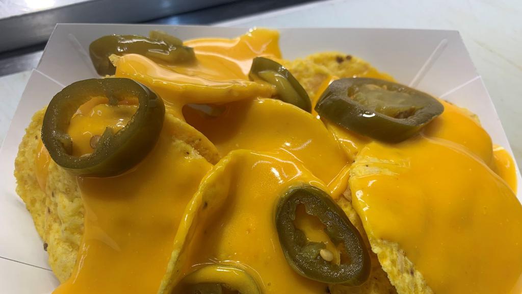 Nachos · Tortilla chips covered in nacho cheese and topped with jalapenos.
