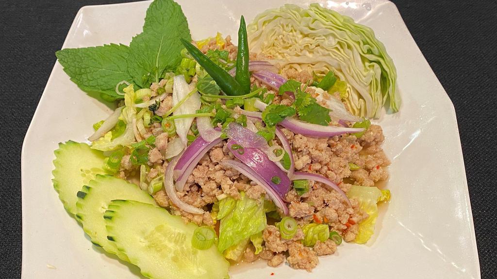 * Larb * · Spicy. Choice of ground chicken or pork in spicy lime dressing fish sauce, with red and green  onions, fresh cilantro, mint, and a touch of rice powder over a bed of romaine lettuce and iceberg lettuce.