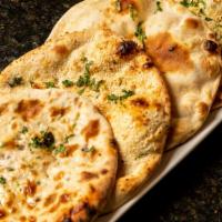 Garlic Naan · White flour leavened bread brushed with fresh garlic, cilantro and baked in the tandoor.
