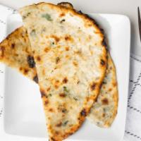 Onion Kulcha · Stuffed white flour leavened bread with onions, special herbs, and baked in the tandoor.