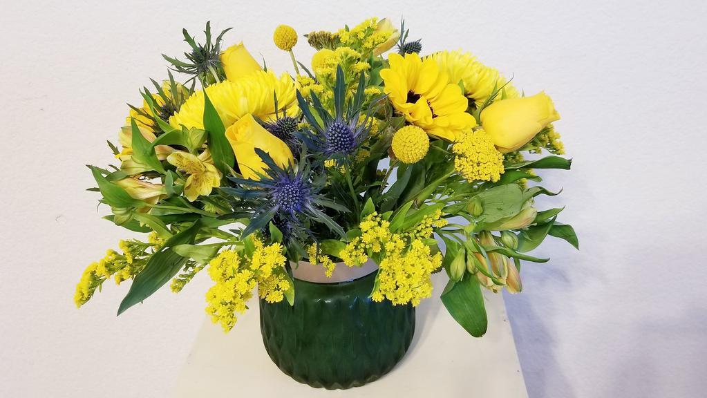 Contemporary Sunshine Arrangement · This bright yellow mixed of Sunflower, yellow Roses, Craspedia, Eryngium, Solidago, Yarrow, Alstroemeria and greenery arrangement is a new and contemporary flower arrangement to make your recipient's heart smile in surprise. Yellow golden blooms and blue Eryngium are hand arranged with yellow rose and pale yellow alstroemerias for a sophisticated floral display. This mixture of bright colored flowers is housed in a glass vase for a gift of sunshine that's truly unforgettable. Send one today and watch them light up! It's a great choice for birthday, get well, thank you, and just because deliveries.
***ENTER CARD MESSAGE UNDER SPECAIL INTRUCTION, PLEASE INDICATE SENDER AND RECEIVER NAME. 
*** NOTE: Flower availability and seasonal variations we may not be able to fill your order exactly as illustrated. Your order will be filled to the specified amount with products of an equal or greater value. As Flower are sensitive items, the size, shade, bloom, and color might difference from the image shown.