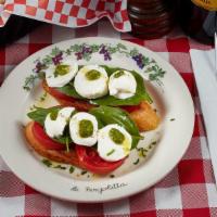 Bruschetta Caprese · Two slices of toasted homemade garlic bread topped with sliced tomatoes, and mozzarella fior...