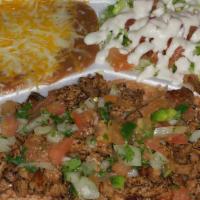 Spanish Rice Asada Plate · Spanish rice covered in marinated steak meat and spicy Pico de Gallo, refried beans with che...