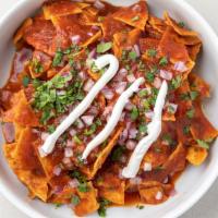 Rojos · Corn tortilla chips, red salsa, fresh cheese, crema, cilantro, onions.