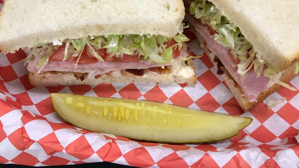 Tanya Harding · Our club sandwich is stacked high with turkey, bacon, ham, and provolone then topped with lettuce, tomato, & mayo on classic white bread.