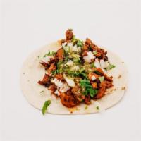 Al Pastor Taco · Marinated Grilled Al Pastor, Cilantro, onions, and salsa verde.