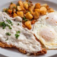 Fried Chicken Steak · Chicken steak with white country gravy, two eggs, red potatoes, and a waffle.