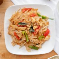Pad Kee Mow · Wide flat noodles stir-fried with tomatoes, onions, bell peppers, basil leaves, in chili gar...