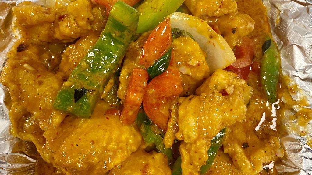 Red Curry Catfish · Lightly coated fried to a crisp catfish fillet sautéed in coconut milk and red curry, chili, bell peppers, onions, and basil leaves.