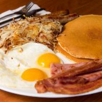 Six Shooter Breakfast · Two eggs, two bacon strips, two sausages, two pieces of ham, two hot cakes or toast and pota...